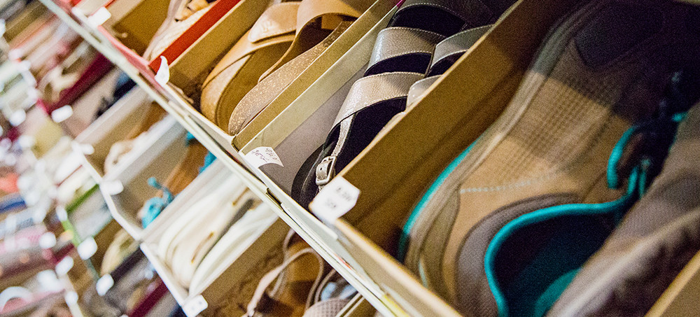 Women's shoes in boxes lining several store shelves